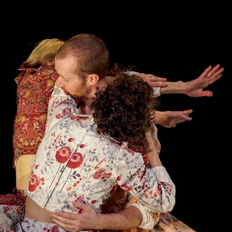 The three artists intertwine. Austin head touches the crook of Sarah's arm.